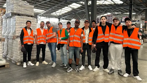 Photo de groupe des apprentis plâtriers de l'ASCM dans l'entrepôt de palettes de Fixit AG Holderbank