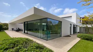 Modernes Einfamilienhaus mit grosser Glasfront und kubistischem Aussehen, weiss verputzt.
