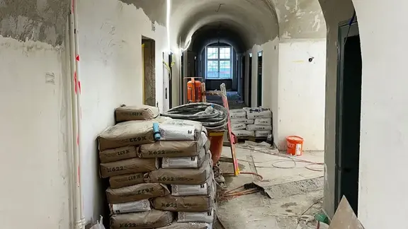 Historischer Flur mit Gewölbedecke und einer Palette Fixit Sanierprodukte